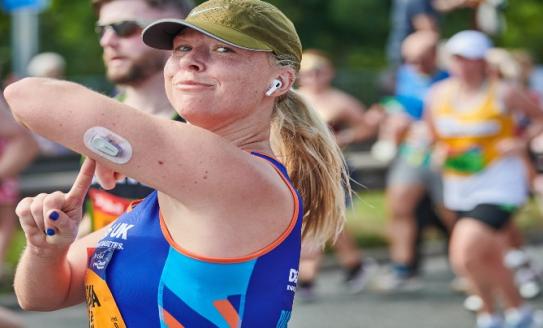 woman running wearing a CGM