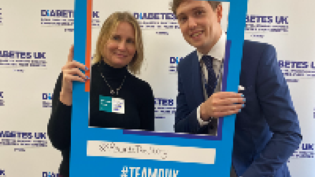 The image shows a women and a man holding a Diabetes UK blue selfie frame.